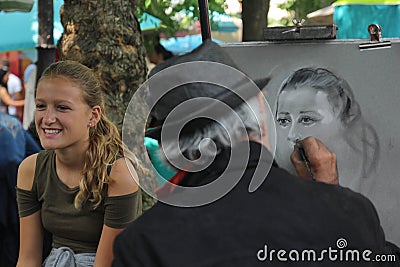 Paris,France - August 27,2017: Artist is drawing portrait for a girl on the street Editorial Stock Photo