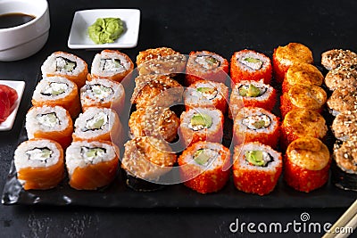 Many sushi , set of Japanese rolls California with caviar, Philadelphia with salmon,baked with cheese and eel, wasabi, pickled Stock Photo