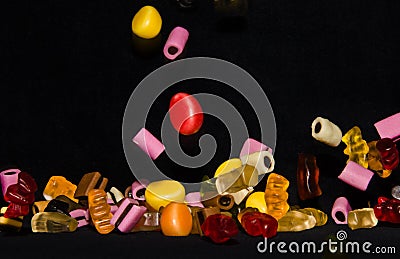 Many sweet and colourful candies are falling down to the table Editorial Stock Photo