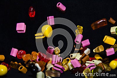 Many sweet and colourful candies are falling down to the table Editorial Stock Photo