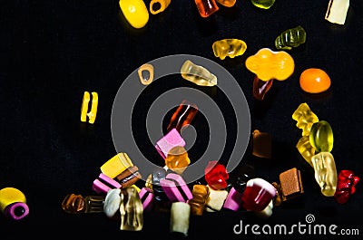 Many sweet and colourful candies are falling down to the table Editorial Stock Photo