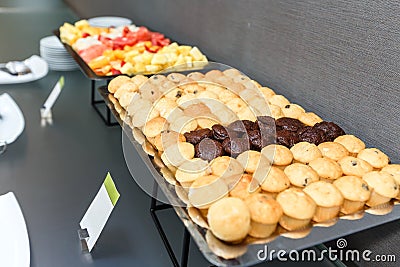 Many Sweet muffins and sliced fruits on table on a coffee break in the office Stock Photo