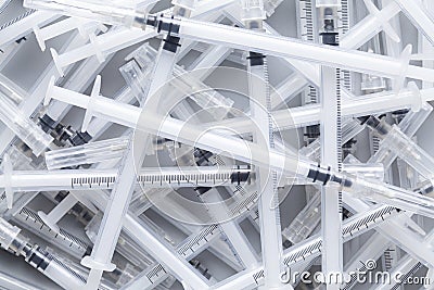 Many syringes with needles on gray background Stock Photo
