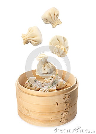 Many tasty dumplings falling into bamboo steamer on background Stock Photo