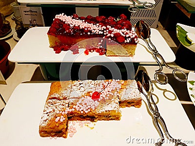 Many type of sweet cake buffet on white plate or dish with stainless steel tongs at hotel. Stock Photo