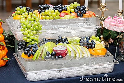 Many useful fruits of grapes, apples, grapes, oranges. The concept is healthy food, party, buffet, catering. Stock Photo