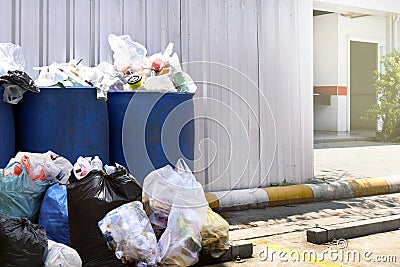Many waste pile at plastic bin blue color for recycle garbage waste outdoors front zinc wall, plastic bin of garbage, bin trash Stock Photo