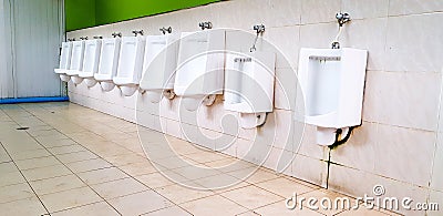 Many white urinal on white dirty wall in men public toilet or rest room Stock Photo