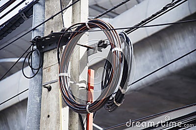 Many wires messy with power line cables on old electricity pillar Stock Photo