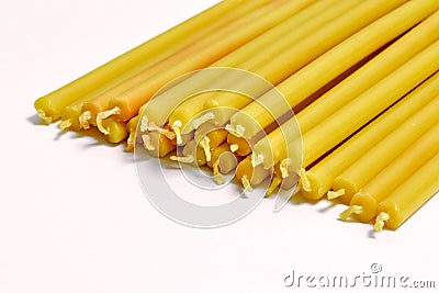 many yellow church candles on white background Stock Photo