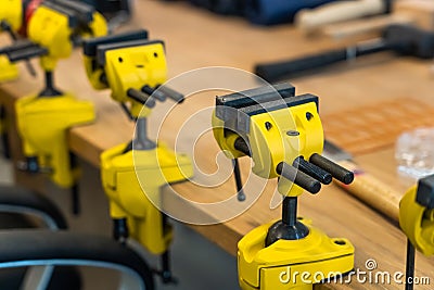Many Yellow Vises are Set on the Work Bench at the School. Stock Photo