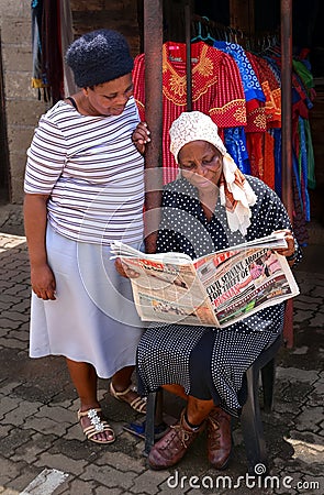 African woman reading the newspaper Editorial Stock Photo