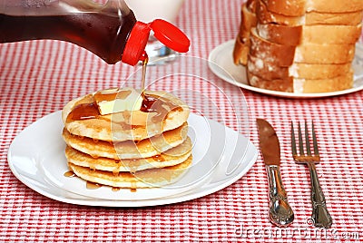 Maple Syrup being poured on a stack of pancakes Stock Photo