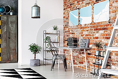 Maps on brick wall of industrial home office Stock Photo