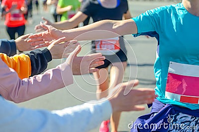 Marathon running race, supporting runners on road, children hands giving highfive Stock Photo