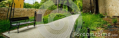 Bench standing on a sidewalk running by the defensive walls Stock Photo