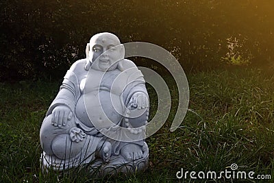 Marble budai hotei in a garden- is a Chinese folkloric deity. Name means `Cloth Sack`, a laughing buddha. Note to the reviewer: Stock Photo