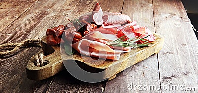 Marble cutting board with prosciutto, bacon, salami and sausages Stock Photo