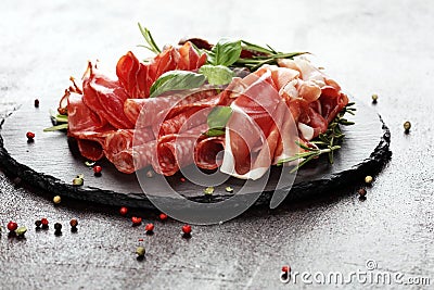 Marble cutting board with prosciutto, bacon, salami and sausages on wooden background. Rustic Meat platter Stock Photo