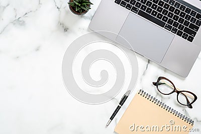 Marble office desk table with laptop computer, paper notepad, glasses, succulent plant, stationery. Minimal flat lay style Editorial Stock Photo