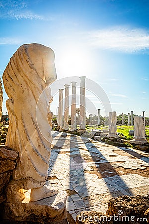 Marble statue under the sun rays and ancient columns at Salamis, Greek and Roman archaeological site, Famagusta, North Cyprus Stock Photo