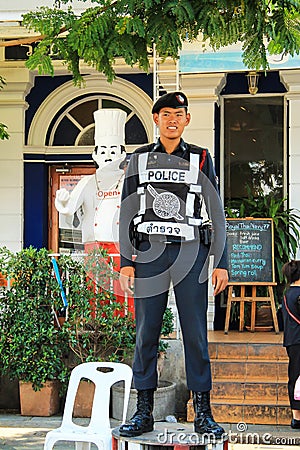 Bangkok, Thailand. A young policeman stands guard outside. Thai police. Man in uniform Editorial Stock Photo