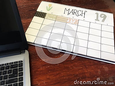 March 19 calendar on desk with laptop computer Stock Photo