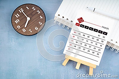 2024 March calendar page and wooden clock on wooden background Stock Photo