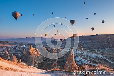 Goreme Cappadocia Turkey hot air balloons fly at pink sunrise over the sandstone mountains in the spring in the off-season Editorial Stock Photo