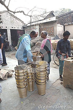 March 3, 2017, Matiari, West Bengal, India. Buyers Checking The Brass Buckets That Were Fabricated At A Nearby Shop. Editorial Stock Photo
