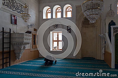 View from the interior of the Kasim TuÄŸmaner Mosque in Mardin, Turkey. Undefined man prays in mosque. Editorial Stock Photo