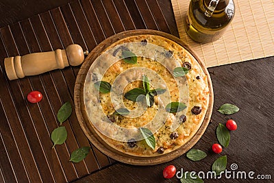 Marguerita pizza with top view, decorated with basil, cherry tomatoes and black olives Stock Photo
