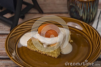 Marijuana vanilla apricot cake on brown dish and wooden table with cup Stock Photo