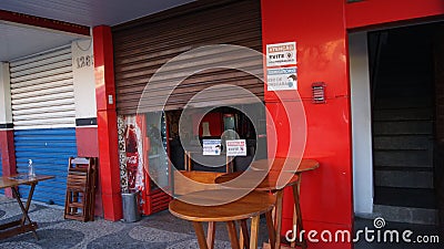 Burger Shop. FaÃ§ade of a burger shop in the interior of Brazil, with ajar door and inscription plate Attention Avoid Crowding Editorial Stock Photo