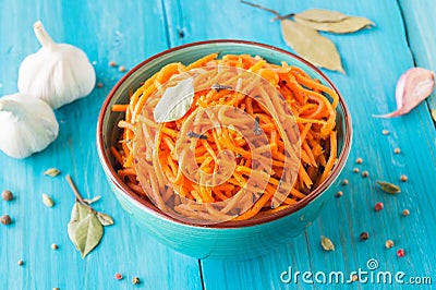 Marinated carrots in Korean style in ceramic ware on a wooden blue background Stock Photo