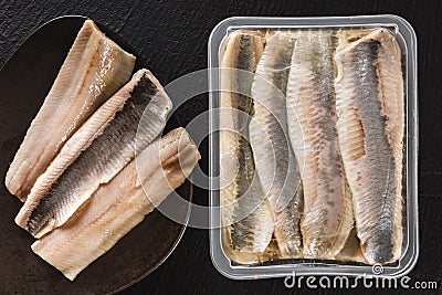 Marinated fillet mackerel or fillet herring fish with oil packed in box on plate over slate stone background. Mediterranean food, Stock Photo