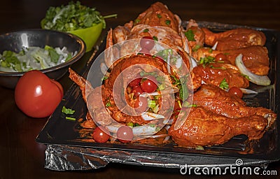Marinated and garnished uncooked tandoori style chicken Stock Photo
