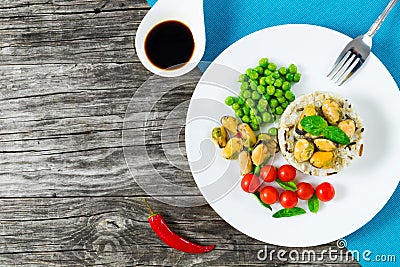 Marinated mussels with brown rice, cherry tomatoes, green peas Stock Photo