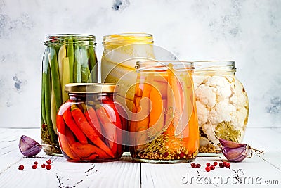 Marinated pickles variety preserving jars. Homemade green beans, squash, cauliflower, carrots, red chili peppers pickles. Stock Photo