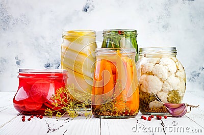 Marinated pickles variety preserving jars. Homemade green beans, squash, radish, carrots, cauliflower pickles. Fermented food Stock Photo