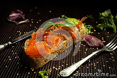 Marinated salmon with basil and sesame seeds on slice of bread Stock Photo