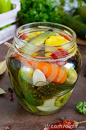 Marinated vegetables in a glass jar. Assorted cucumbers, peppers, carrots, patissons, zucchini. Stock Photo