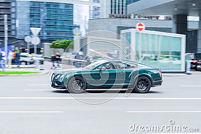 Marine Blue color premium car Bentley Continental GT Speed riding in the city street. Side view of fast moving fastback coupe car Editorial Stock Photo