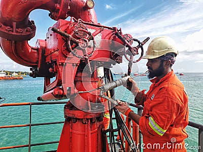 Marine crew servicing FiFi water monitor Editorial Stock Photo