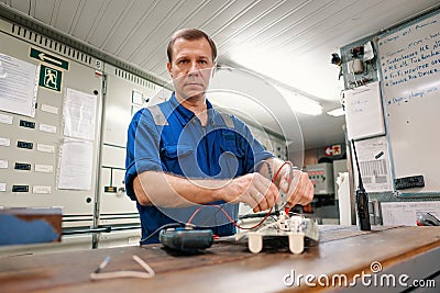 Marine electrical engineer officer in engine control room ECR. He works in workshop Stock Photo