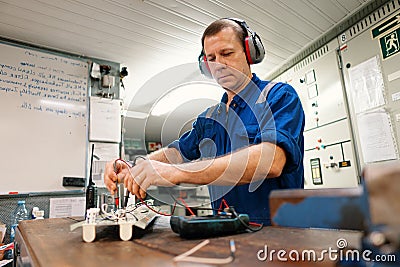 Marine electrical engineer officer in engine control room ECR. He works in workshop Stock Photo