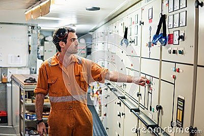 Marine engineer officer controlling vessel engines in engine control room ECR Stock Photo