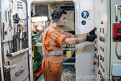 Marine engineer officer controlling vessel engines in engine control room ECR Stock Photo