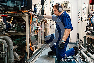 Marine engineer officer controlling vessel enginesand propulsion in engine control room ECR Stock Photo