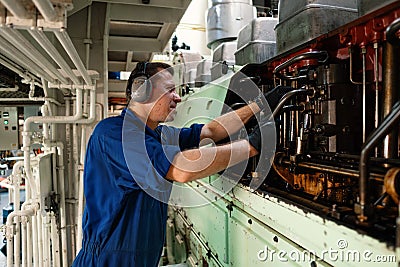 Marine engineer officer controlling vessel enginesand propulsion in engine control room ECR Stock Photo